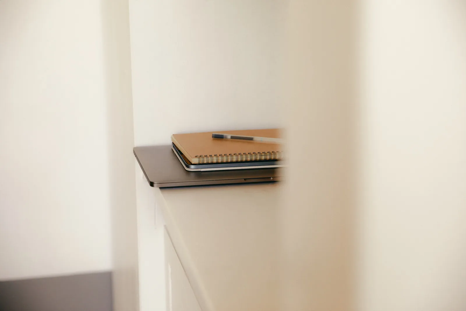 A laptop and notebook set down — a website project, handled